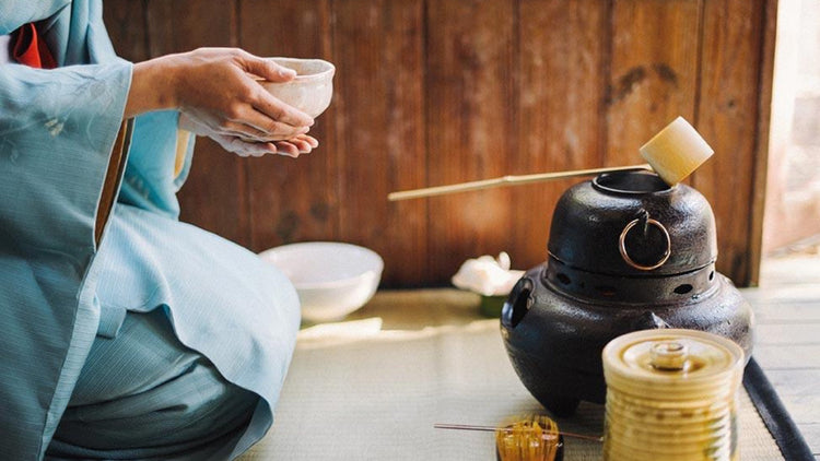 Traditional Japanese Tea Ceremony with a women holding a chawan of matcha green tea